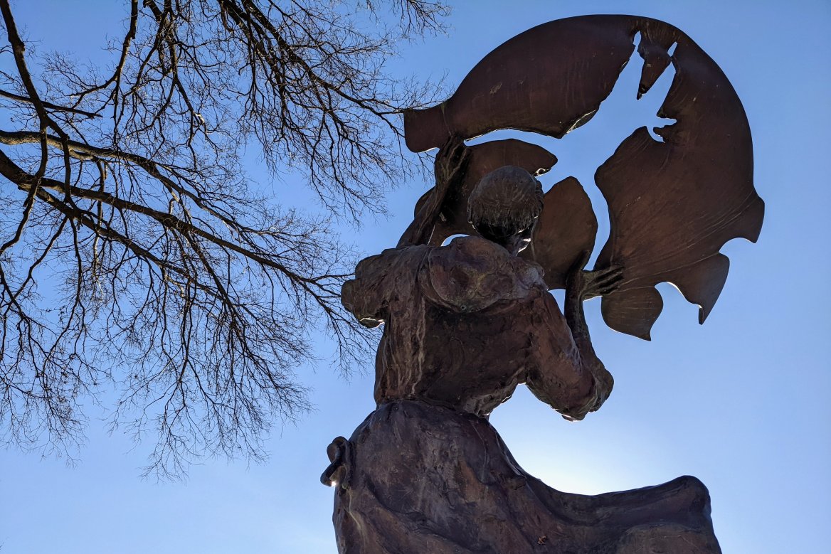 statue of st francis of assisi with a blue sky